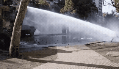 Truck Spraying Water On Sidewalk With Smoke GIF
