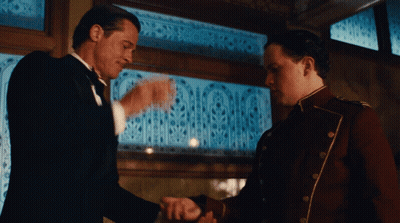 Tuxedo Man Shaking Hands With Red Uniform Man GIF