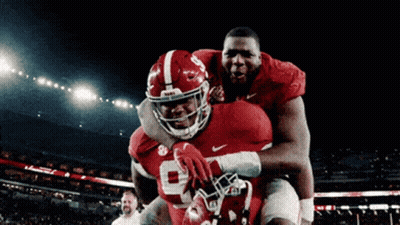 Two Alabama Football Players Hugging On Field GIF