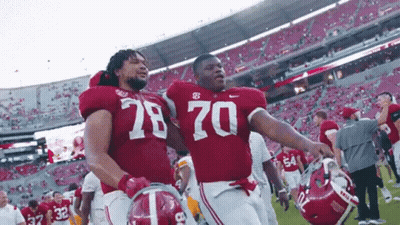 Two Alabama Football Players Wearing Number 78 And 70 Walk Off The Field GIF
