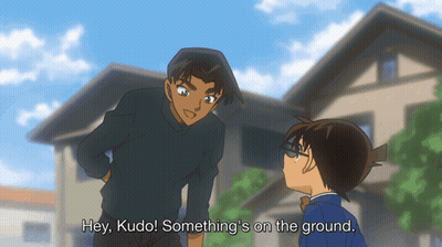 Two Anime Characters Are Standing Next To Each Other With The Words Hey Kudo Something 'S On The Ground Below Them GIF