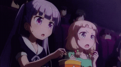 Two Anime Girls Are Sitting In A Movie Theater Eating Popcorn And Watching A Movie . GIF