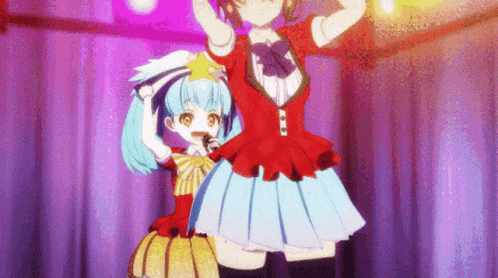 Two Anime Girls Are Standing On A Stage With Their Arms In The Air GIF