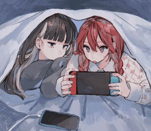 Two Anime Girls Laying Under A Blanket Playing A Game GIF