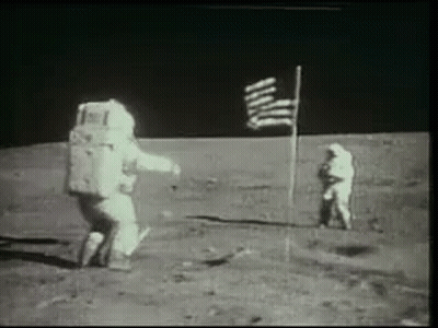 Two Astronauts Are Standing On The Moon Next To An American Flag . GIF