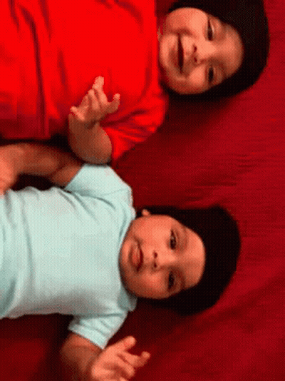 Two Babies Laying On Red Blanket GIF