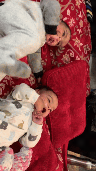 Two Babies Lying Next To Each Other GIF