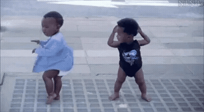 Two Baby Boys Are Dancing On A Sidewalk . GIF