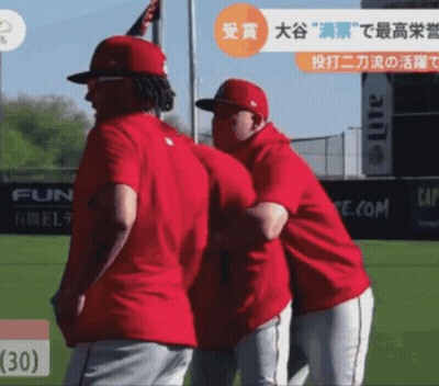 Two Baseball Players Are Hugging Each Other On A Field With A Lite Ad In The Background GIF