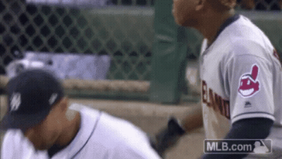 Two Baseball Players Are Standing Next To Each Other On The Field . One Of The Players Is Wearing An Indians Jersey . GIF