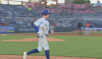 Two Baseball Players Are Standing On A Field With Advertisements On The Wall GIF