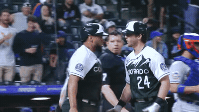 Two Baseball Players From The Colorado Rockies Are Shaking Hands GIF