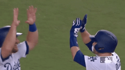 Two Baseball Players Hugging Each Other On The Field . GIF