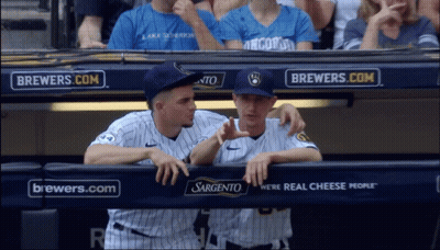Two Baseball Players In A Dugout With Brewers.com Advertisements Behind Them GIF