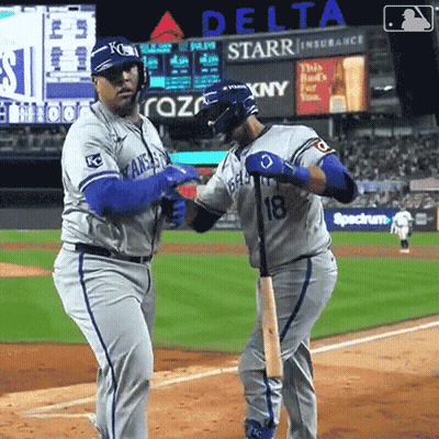 Two Baseball Players On A Field With A Delta Advertisement In The Background GIF