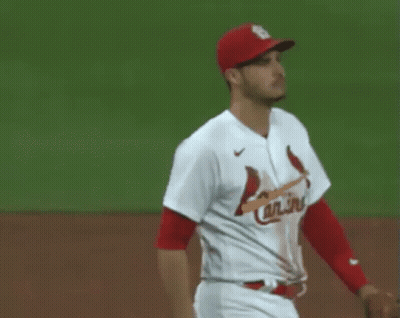 Two Baseball Players , One Wearing A Red Hat And The Other Wearing A White Jersey , Are Shaking Hands On The Field . GIF
