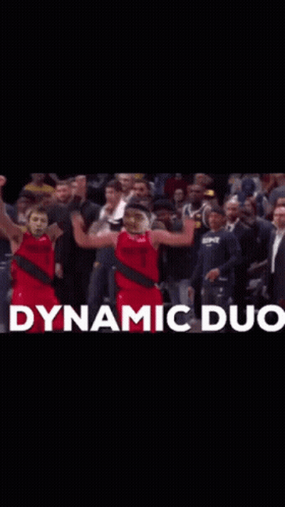 Two Basketball Players Are Celebrating In Front Of A Crowd With Dynamic Duo Written In White GIF