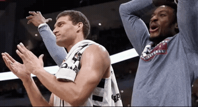 Two Basketball Players Are Clapping Their Hands And One Has A Shirt That Says Basketball On It GIF