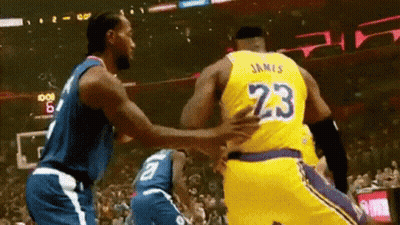 Two Basketball Players Are Hugging Each Other On A Court . GIF