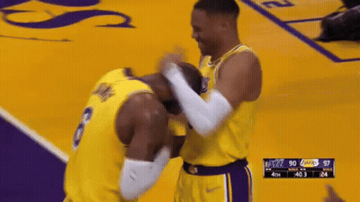 Two Basketball Players Are Hugging Each Other On A Court During A Game . GIF