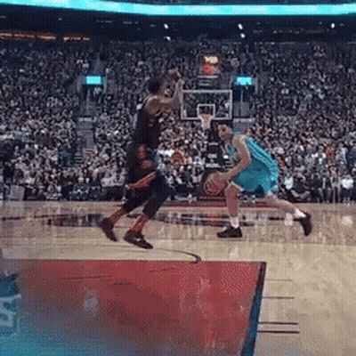 Two Basketball Players Are Playing A Game Of Basketball In Front Of A Crowd . GIF