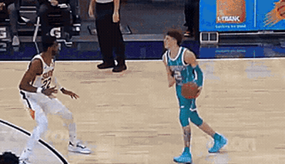Two Basketball Players Are Playing A Game Of Basketball On A Court And One Of Them Is Dribbling The Ball . GIF