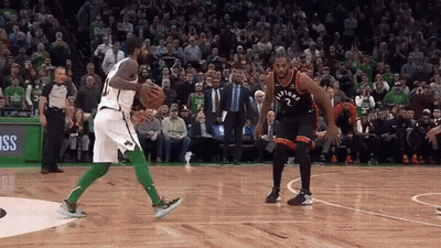 Two Basketball Players Are Playing A Game Of Basketball On A Court With A Crowd Watching . GIF