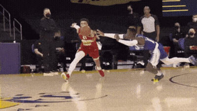 Two Basketball Players Are Playing A Game Of Basketball On A Court With A Referee In The Background . GIF