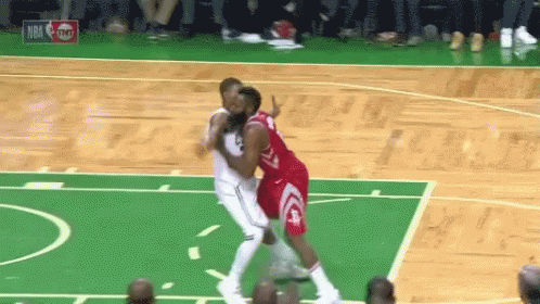 Two Basketball Players Are Playing A Game Of Basketball On A Green Court . GIF