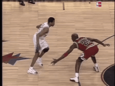 Two Basketball Players Are Playing A Game On A Court . GIF