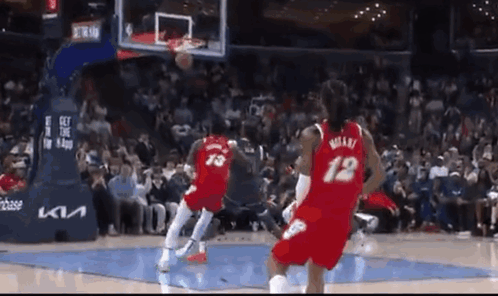 Two Basketball Players Are Playing Basketball On A Court . GIF