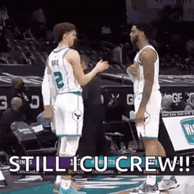 Two Basketball Players Are Standing Next To Each Other On The Court Talking To Each Other . GIF