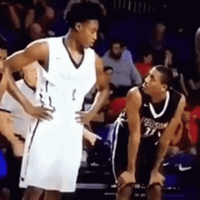 Two Basketball Players Are Talking To Each Other On The Court . GIF