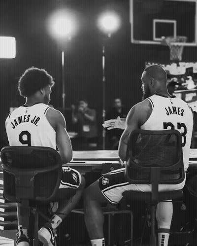 Two Basketball Players Giving Each Other A High Five With James Jr. Wearing Number 9 GIF