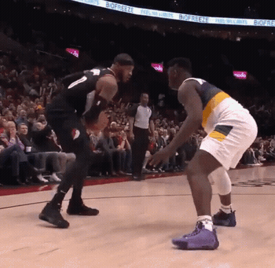 Two Basketball Players On A Court With Biofreeze Advertisements On The Wall GIF