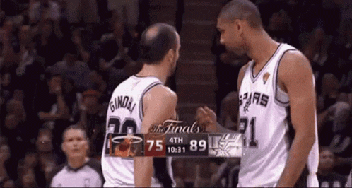 Two Basketball Players Shake Hands In Front Of A Scoreboard That Says The Finals On It GIF