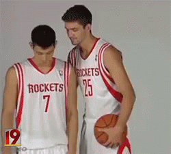 Two Basketball Players Wearing Rockets Jerseys Stand Next To Each Other GIF
