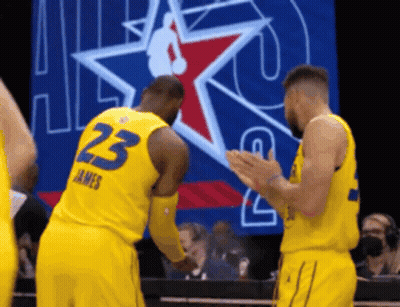 Two Basketball Players Wearing Yellow Uniforms With The Number 23 On The Back GIF