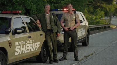 Two Beacon County Sheriffs Standing By Cars GIF