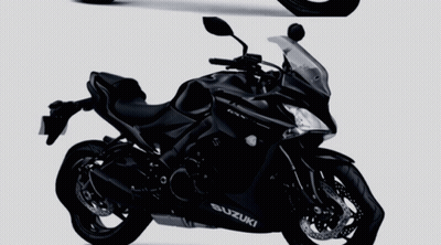 Two Black Suzuki Motorcycles Side By Side On A Gray Background GIF