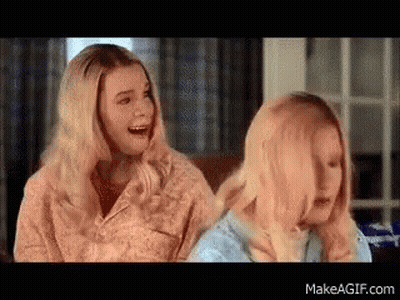 Two Blonde Women Are Sitting Next To Each Other On A Couch Laughing . GIF