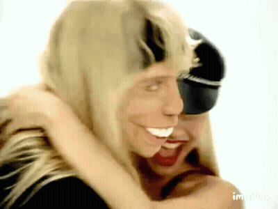 Two Blonde Women Hugging One In Black Hat GIF