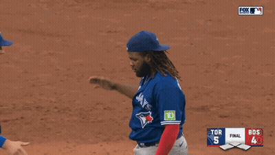 two blue jays players shake hands during a baseball game