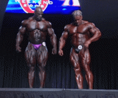 Two Bodybuilders On Stage In Front Of Pepsi Sign GIF