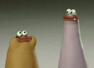 Two Bottles With Googly Eyes Are Sitting Next To Each Other On A Table . GIF