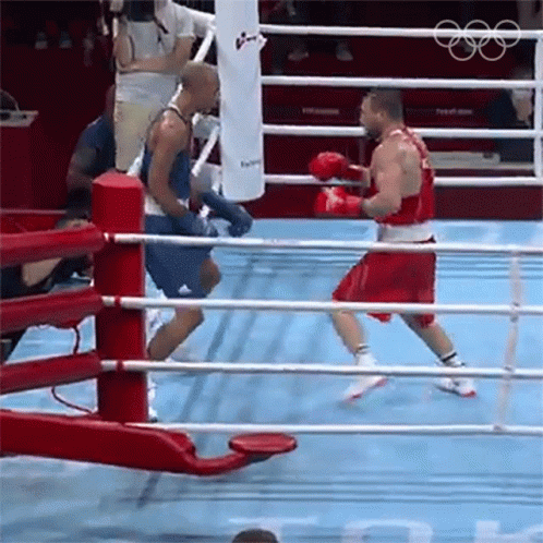 Two Boxers Are Fighting In A Boxing Ring And One Is Wearing Red Shorts GIF