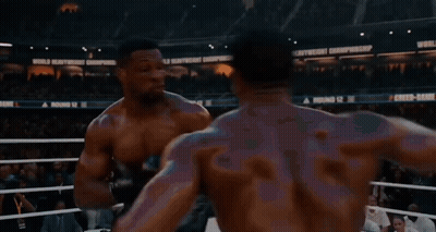 Two Boxers Are Fighting In A Ring With A Sign That Says World Heavyweight Championship In The Background GIF