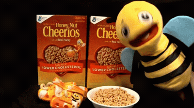 Two Boxes Of Honey Nut Cheerios Next To A Bee GIF