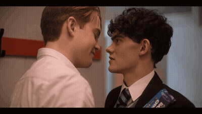 Two Boys Are Looking At Each Other And One Of Them Has A Bar Of Oreo On His Back GIF