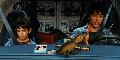 Two Boys Are Sitting In A Car With A Yellow Sticker That Says Do N't Bru GIF